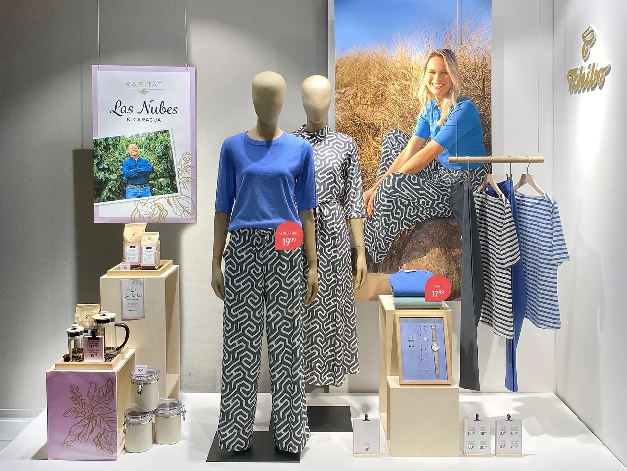 Schaufenster mit bekleideten Schaufensterpuppen und Kaffeeprodukten.