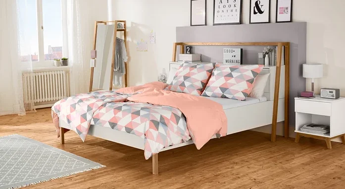 Schlafzimmer mit Bett, Nachttisch und Spiegel.