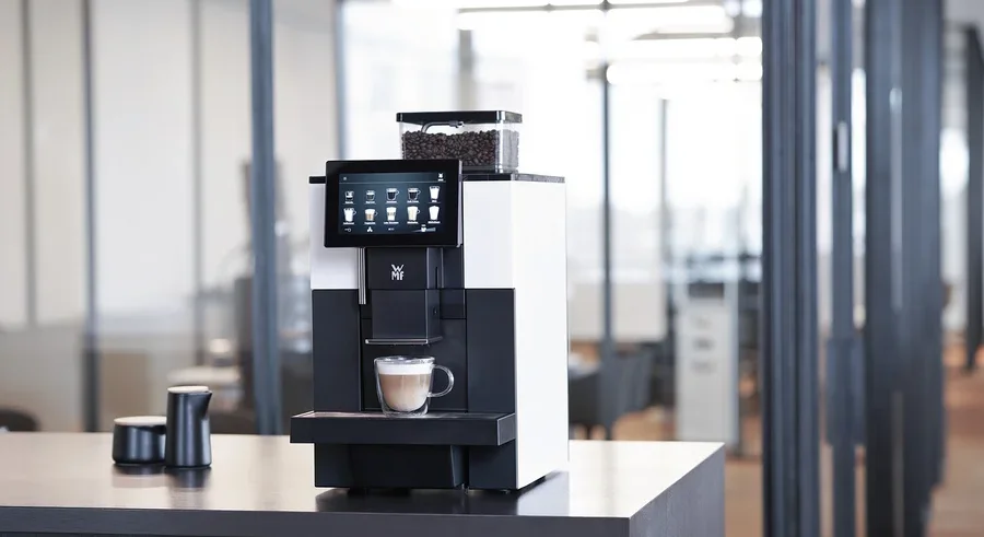 WMF 950 S Profi-Kaffeevollautomat mit Tasse Cappuccino auf einem Tisch.