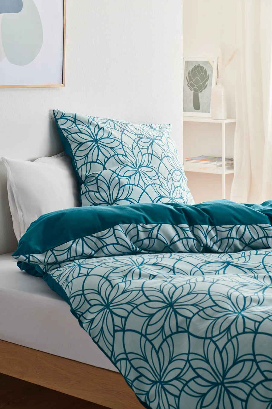 Bett mit Biber-Bettwäsche, Normalgröße, mit Blumenmuster und unifarbenem Rand.