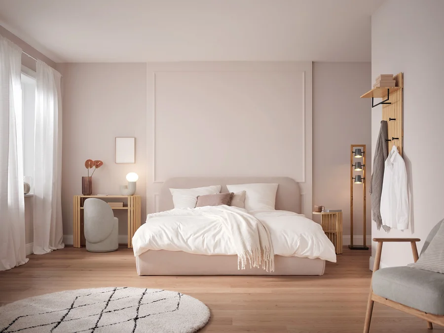 Schlafzimmer mit Bett mit weißer Bettwäsche, Tisch, Stuhl und Dekorationen.