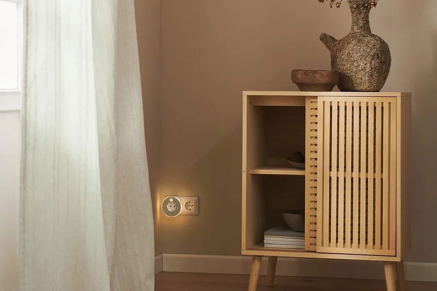 Im Raum stehen eine Kommode und ein LED-Nachtlicht mit Steckdose. Am Fenster hängen 2 Vorhangschals.