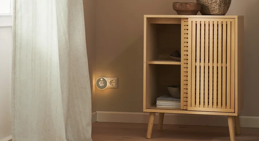 Im Raum stehen eine Kommode und ein LED-Nachtlicht mit Steckdose. Am Fenster hängen 2 Vorhangschals.