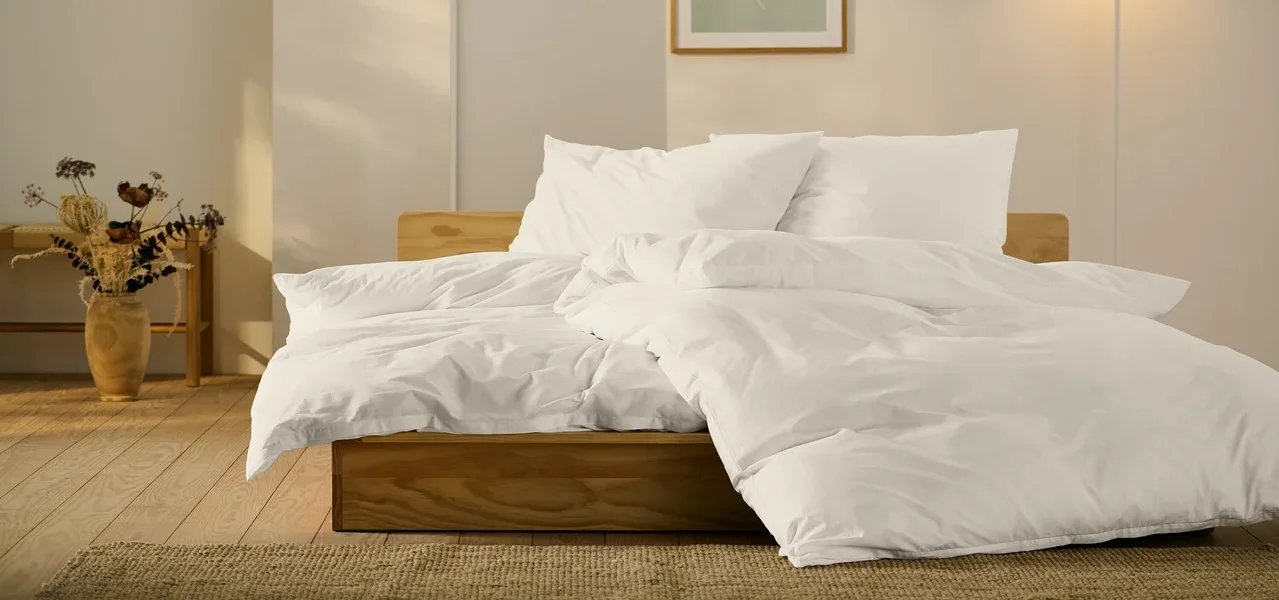 Bett mit weißer Perkal-Bettwäsche in Standard- und Übergröße.