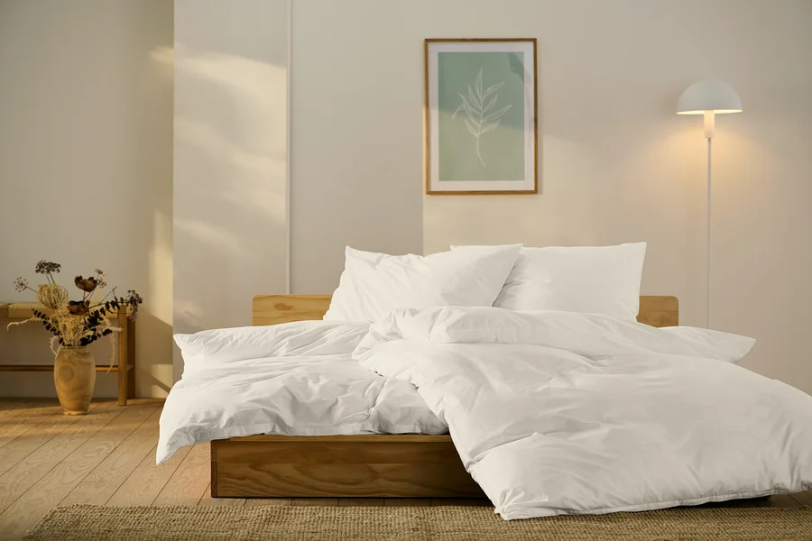 Bett mit weißer Perkal-Bettwäsche in Standard- und Übergröße.