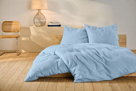 Helles blaues Leinen-Bettwäsche-Set in Standardgröße auf einem Bett.