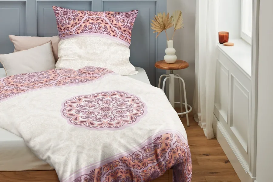 Perkal-Bettwäsche mit Blumenmuster auf einem Bett.