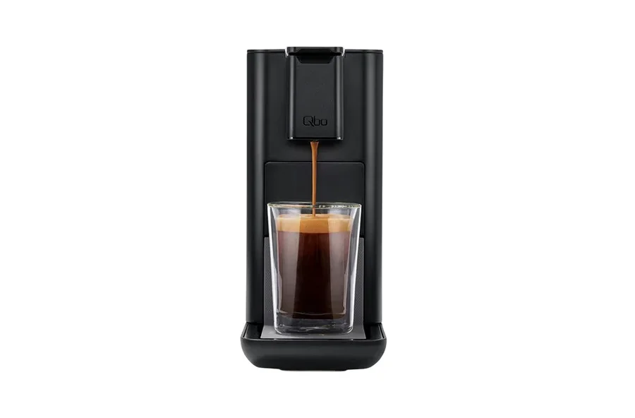 Eine schwarze Qbo-Kaffeemaschine, die Kaffee in ein Glas ausgibt.
