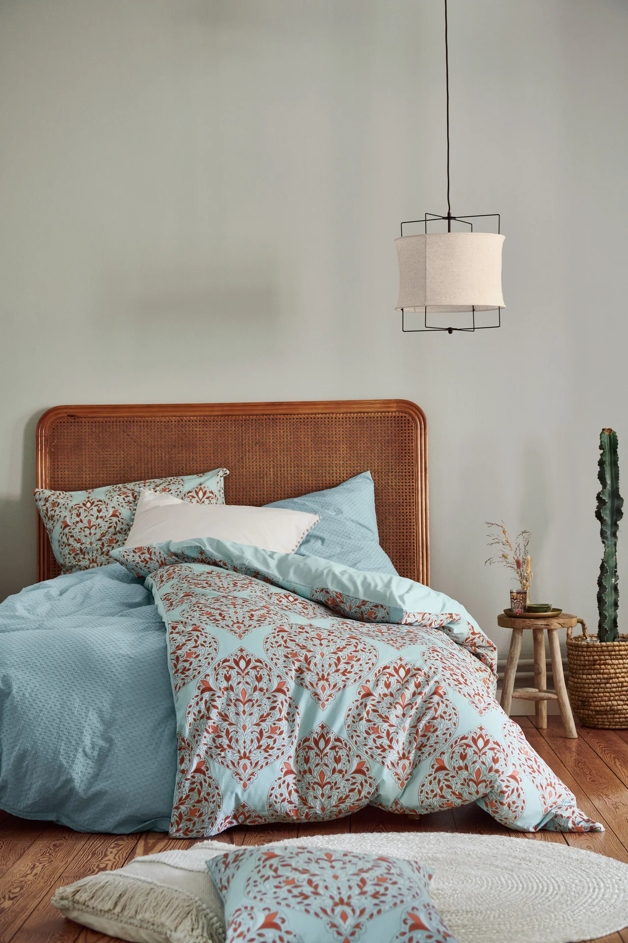 Schlafzimmer mit einem Bett mit beiger Premium-Baumwoll-Bettwäsche und einer Pendelleuchte mit Textilschirm.