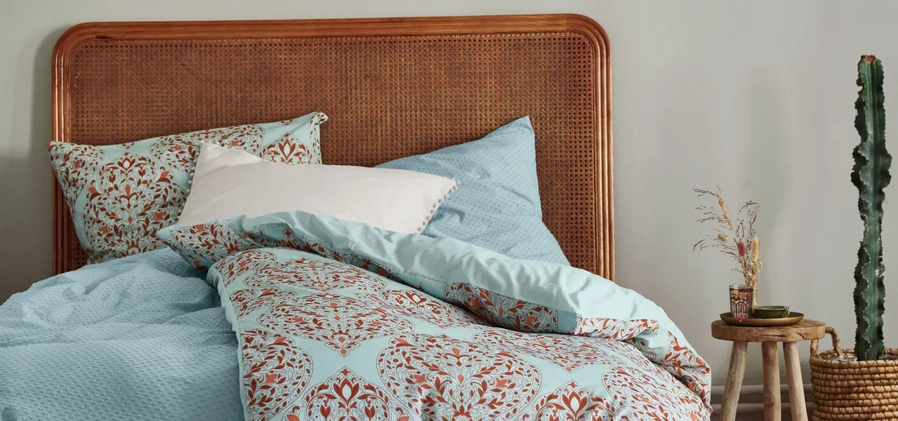 Schlafzimmer mit einem Bett mit beiger Premium-Baumwoll-Bettwäsche und einer Pendelleuchte mit Textilschirm.