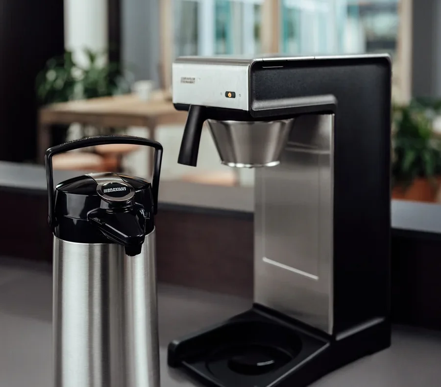 Eine silberne Bonamat Pumpthermoskanne 2,2 l neben einer professionellen Bravilor-Bonamat TH Filterkaffeemaschine ohne Kanne.
