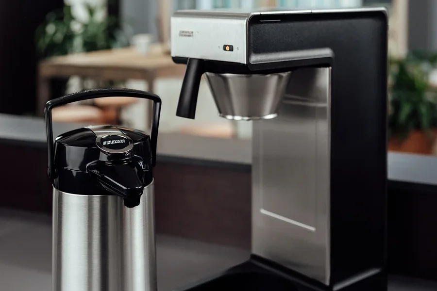 Eine silberne Bonamat Pumpthermoskanne 2,2 l neben einer professionellen Bravilor-Bonamat TH Filterkaffeemaschine ohne Kanne.