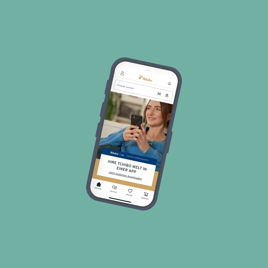 Ein Handy zeigt die Tchibo-App mit einer Frau, die ein Telefon hält.