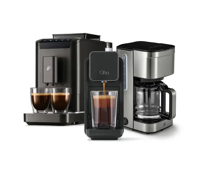 Drei Kaffeemaschinen: links eine dunkelgraue Espressomaschine mit zwei gefüllten Gläsern, mittig eine schwarze Qbo-Kapselmaschine, die Kaffee in ein Glas füllt, und rechts eine silberne Filterkaffeemaschine.