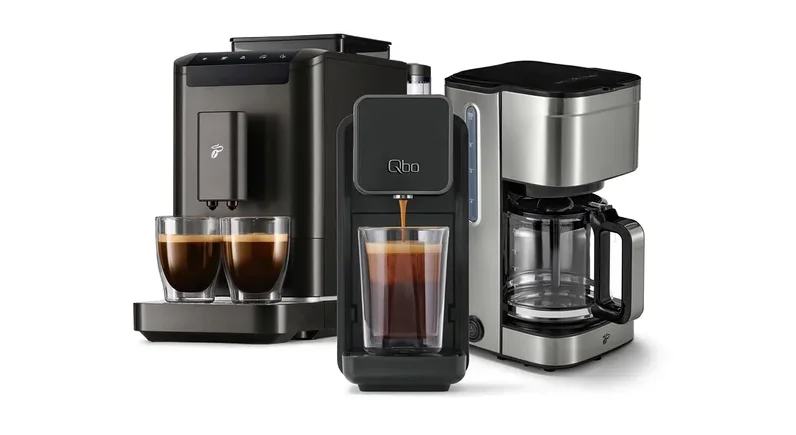 Drei Kaffeemaschinen: links eine dunkelgraue Espressomaschine mit zwei gefüllten Gläsern, mittig eine schwarze Qbo-Kapselmaschine, die Kaffee in ein Glas füllt, und rechts eine silberne Filterkaffeemaschine.