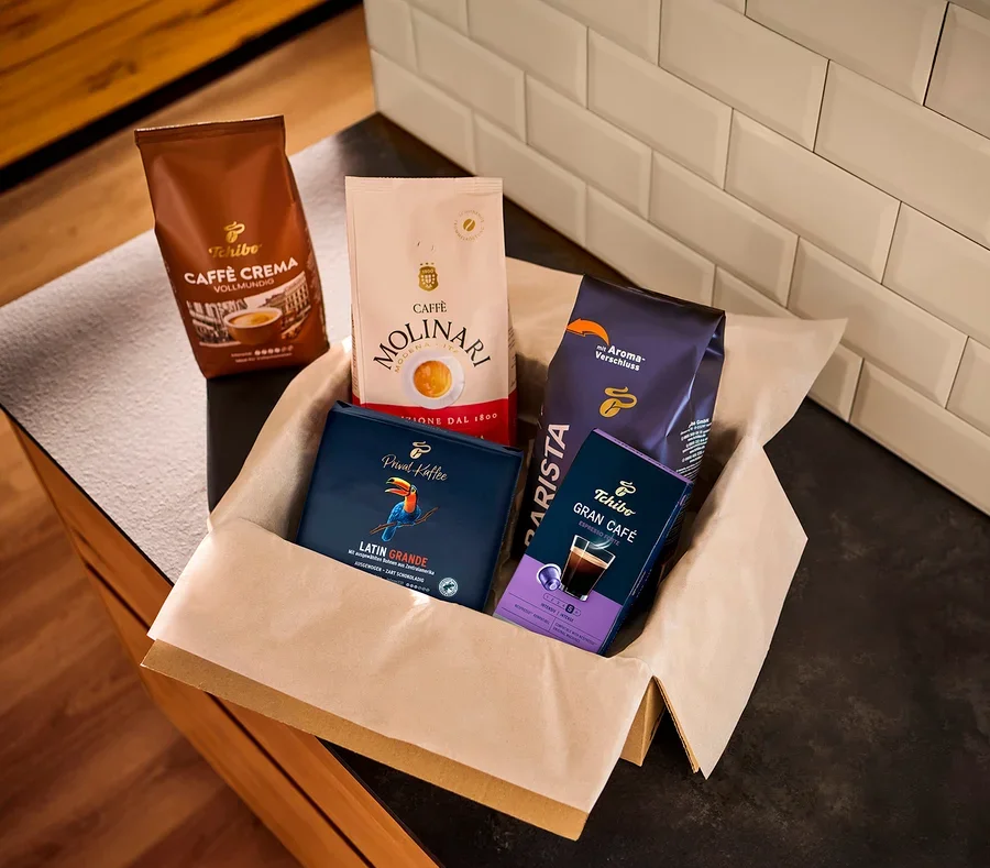 Eine Auswahl an Kaffeepackungen verschiedener Marken in einer Papierbox.