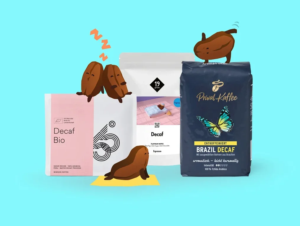 Drei Packungen entkoffeinierten Kaffees auf hellblauem Hintergrund. Die pinke „Decaf Bio“-Packung hat zwei schlafende Kaffeebohnen und eine schlafende Seehund-Bohne. Eine weiße „Decaf Espresso“-Packung ist in der Mitte, und eine dunkelblaue „Privat Kaffee Brazil Decaf“-Packung hat eine springende Kaffeebohne oben.