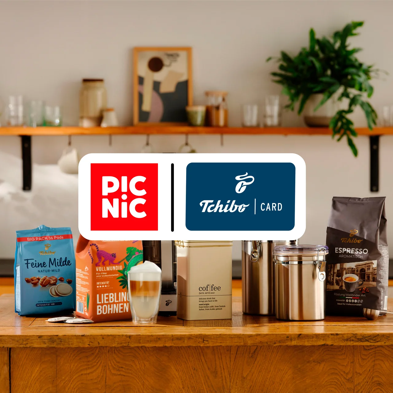 Verschiedene Tchibo Kaffeeprodukte, darunter Pads, ganze Bohnen und ein Latte Macchiato, stehen zusammen mit Kaffeedosen auf einer Holzküchenzeile. Darüber liegen die roten Picnic- und blauen Tchibo Card-Logos.