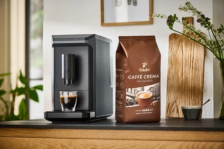Eine graue »Esperto mini« und eine Packung Caffè Crema Vollmundig stehen auf einer Theke.