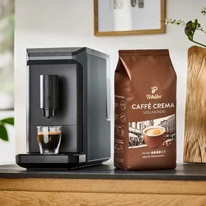 Eine graue »Esperto mini« und eine Packung Caffè Crema Vollmundig stehen auf einer Theke.