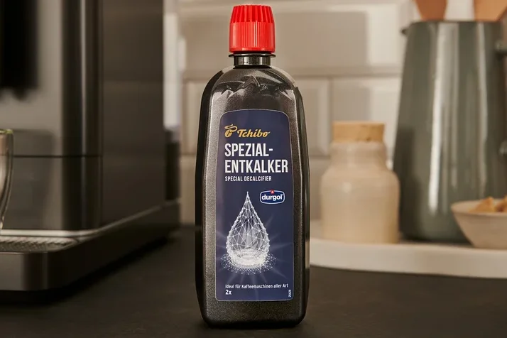 Eine schwarze Flasche durgol® Spezial-Entkalker, 400 ml, steht auf der Theke neben einer Kaffeemaschine.