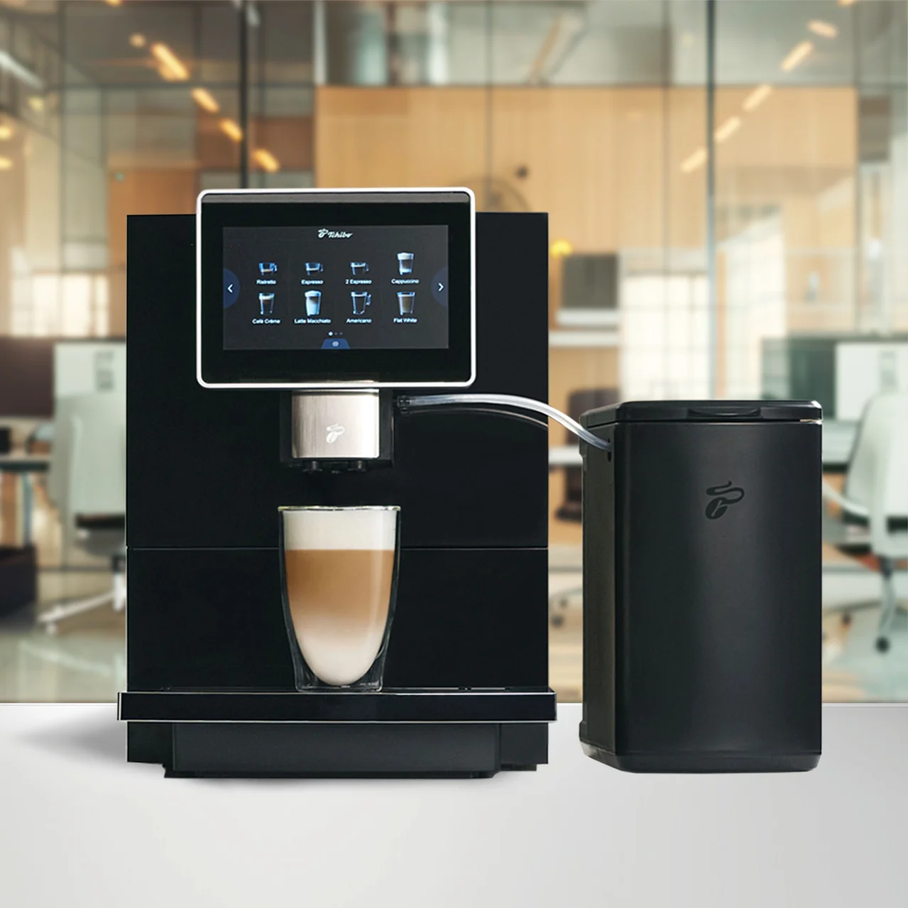 Schwarze Kaffeemaschine mit Touchscreen-Display, das Kaffeeoptionen zeigt, und einem Glas Latte Macchiato darunter. Daneben steht ein schwarzer Milchbehälter.