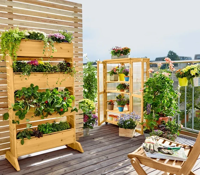 Holzregal mit Pflanzen auf einem Balkon.