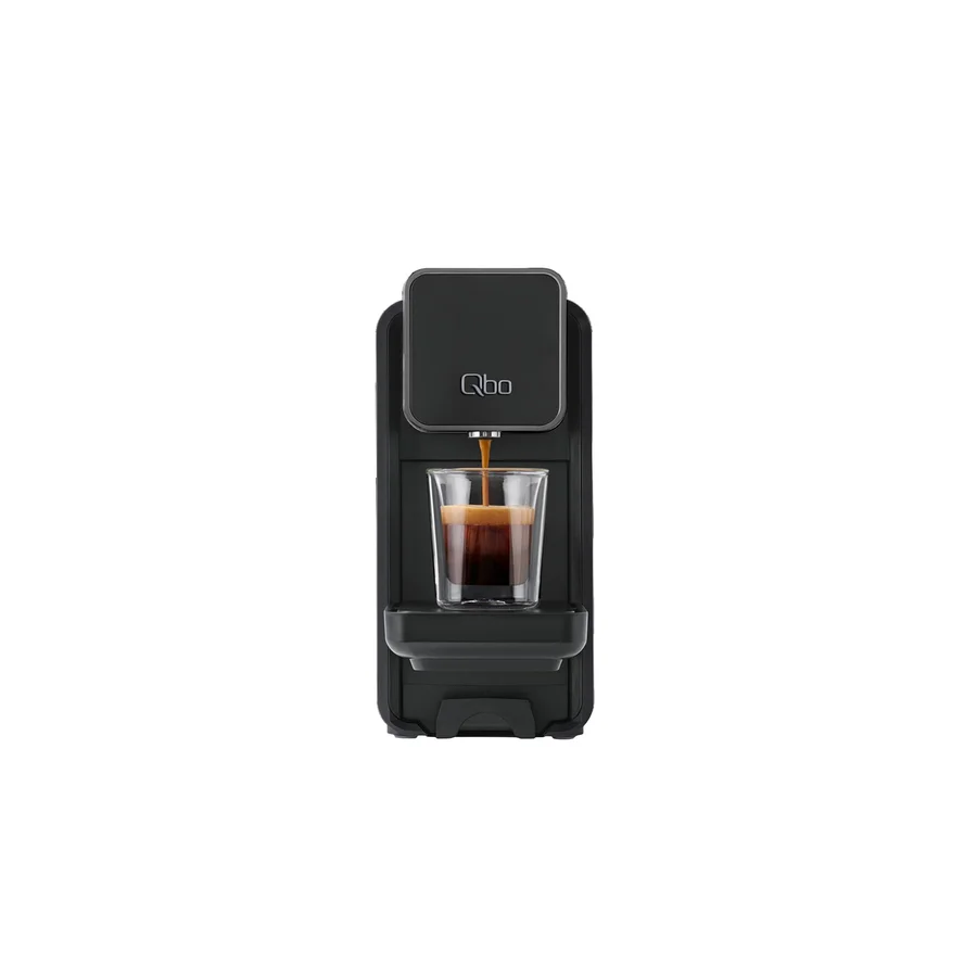 Espresso läuft aus einer schwarzen Qbo-Kaffeemaschine in ein Glas.