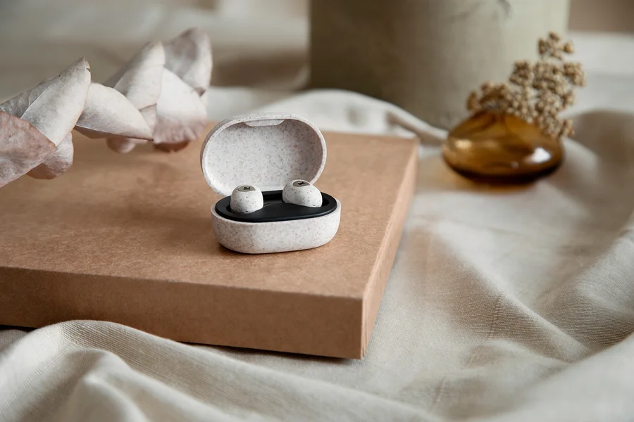 Ein Etui mit einem Paar Kreafunk Care In-Ear-Bluetooth®-Kopfhörern »aBEAN« auf einem Karton.