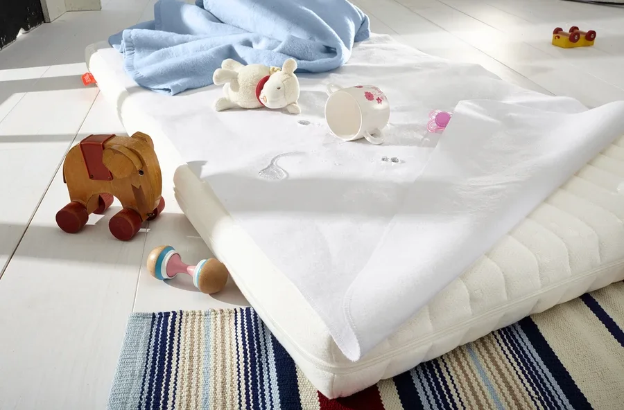 Ein Kinderbett mit Spielzeug und einer Decke.