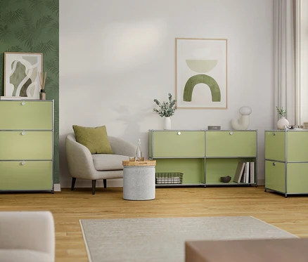 Wohnzimmer mit hellgrünen modularen Aufbewahrungseinheiten, Sessel und Deko.