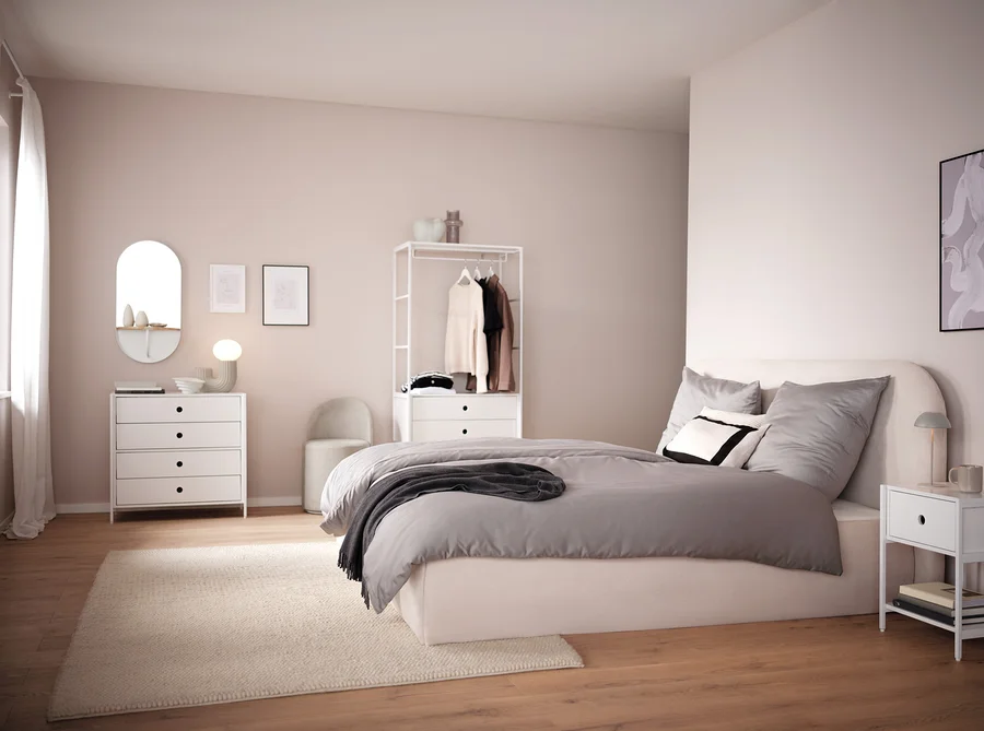 Schlafzimmer mit weißen Möbeln und grauer LED-Akku-Tischleuchte auf dem Nachttisch.