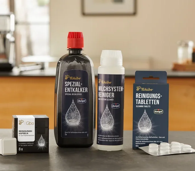 Auf einem Tisch stehen durgol® Spezial-Entkalker, durgol® Milchsystem-Reiniger und durgol® Reinigungstabletten für Kaffeeöle.