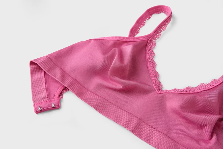 Nahaufnahme eines pinkfarbenen BHs mit Spitze am Ausschnitt.
