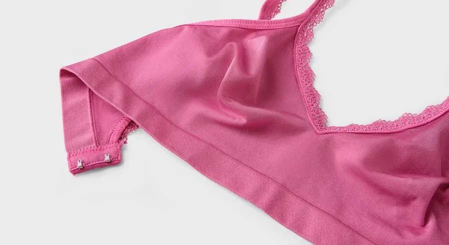 Nahaufnahme eines pinkfarbenen BHs mit Spitze am Ausschnitt.