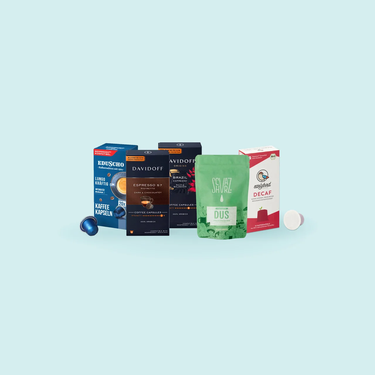 Sortiment an Kaffeeprodukten, darunter eine Packung Eduscho Lungo Kräftig Kaffeekapseln mit einer blauen Kapsel, eine Packung Davidoff Espresso 57 Ristretto Kapseln, eine Packung Avidoff Origins Brazil Espresso Kapseln, ein grüner Sevaz Dus Kaffeebeutel und eine Packung Earlybird Decaf Kaffeekapseln mit einer weiß-roten Kapsel.