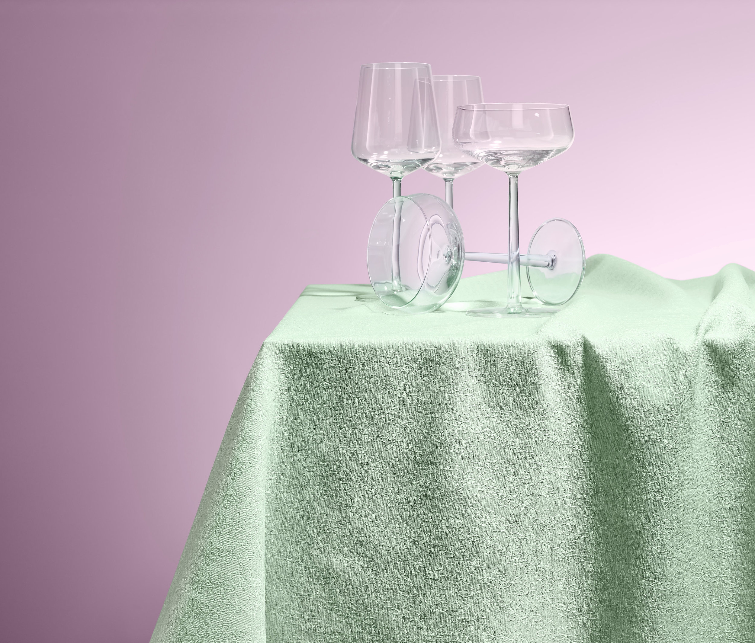 Vier Gläser stehen auf einem Tisch mit einer Jacquard-Tafeldecke.