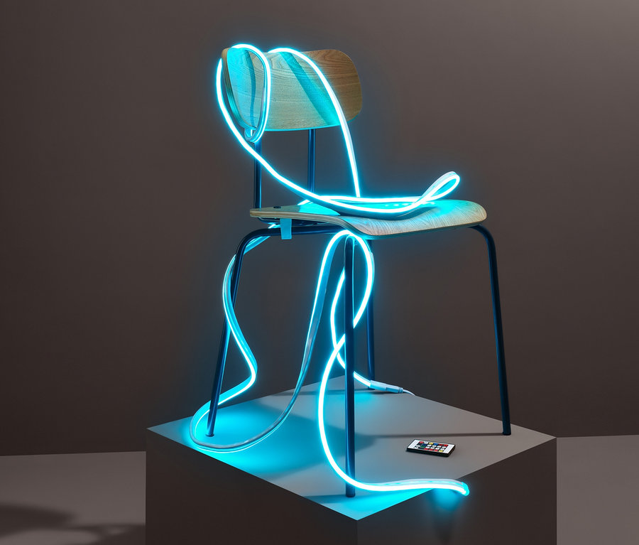 Ein blauer LED-Leuchtschlauch mit Lichteffekten ist um einen Stuhl gewickelt, der auf einem grauen Sockel steht. Eine Fernbedienung liegt auf dem Sockel.