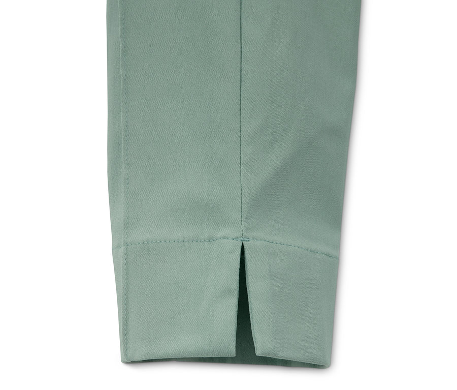 Detail einer mintfarbenen Stretchhose mit Schlitz am Saum.