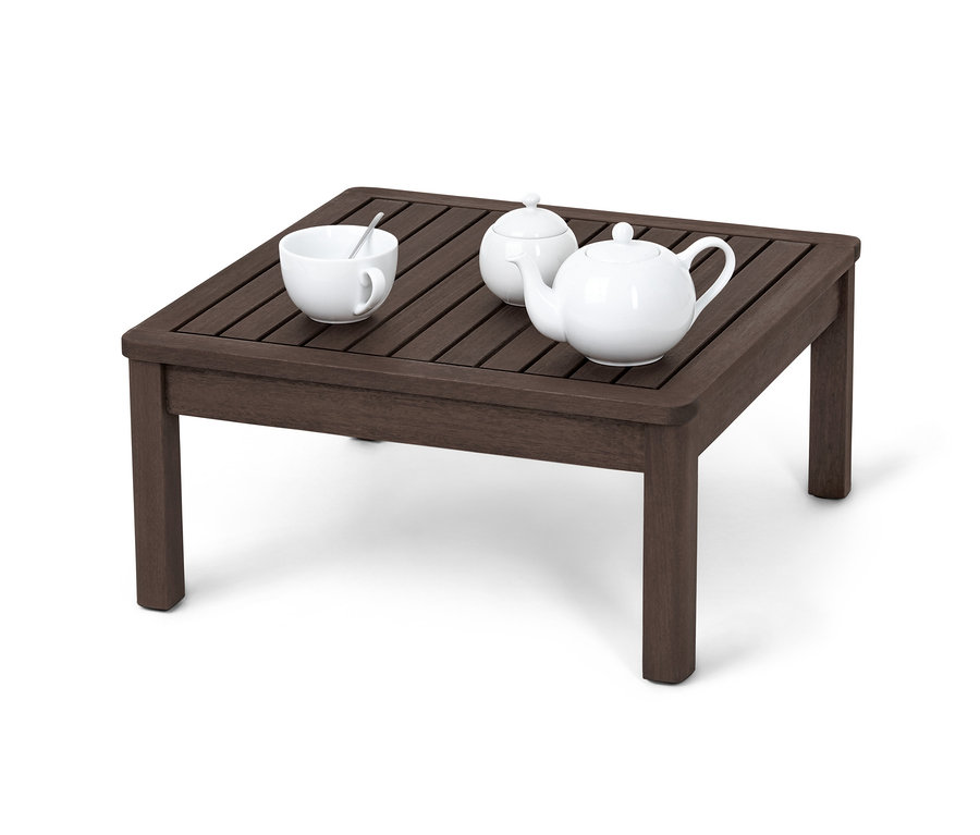 Auf einem braunen Beistelltisch mit höhenverstellbarer Tischplatte stehen eine weiße Tasse mit Löffel, eine Zuckerdose und eine Teekanne.