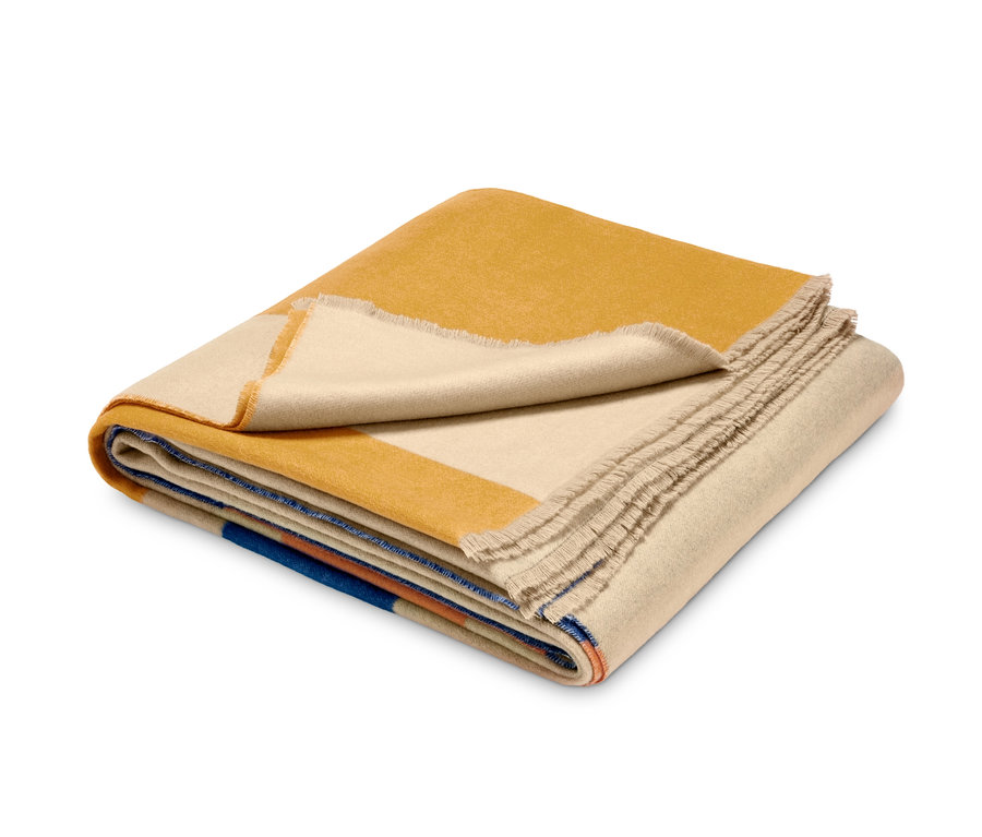 Gefaltetes Premium Plaid mit geometrischem Muster in Gelb, Beige, Blau und Orange.