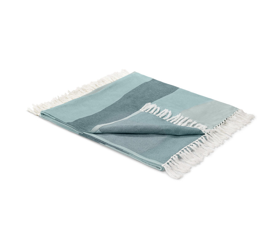 Gefaltete Wohndecke mit Fransen.