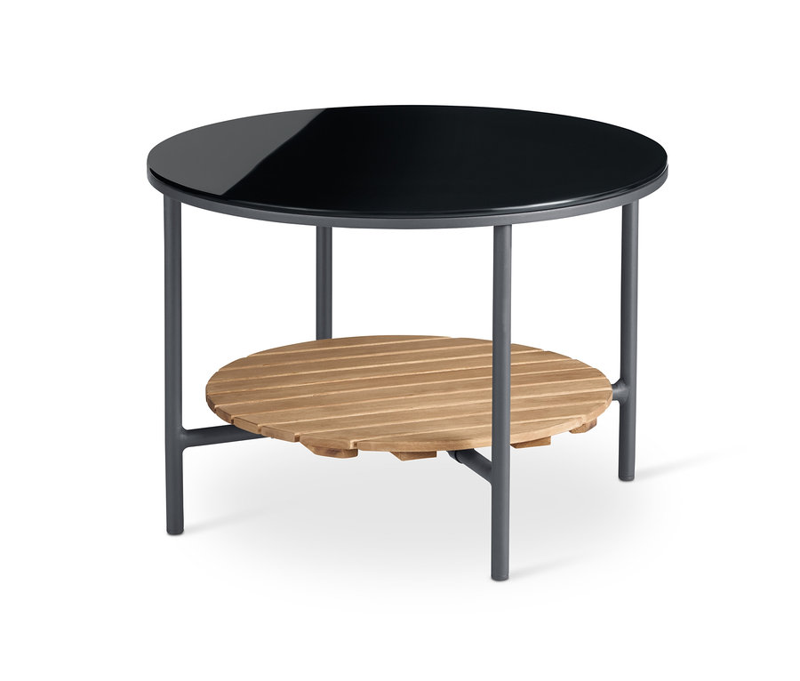 Detailansicht eines runden Couchtisches »Elin« mit schwarzer Glasplatte und Ablage aus Holz.