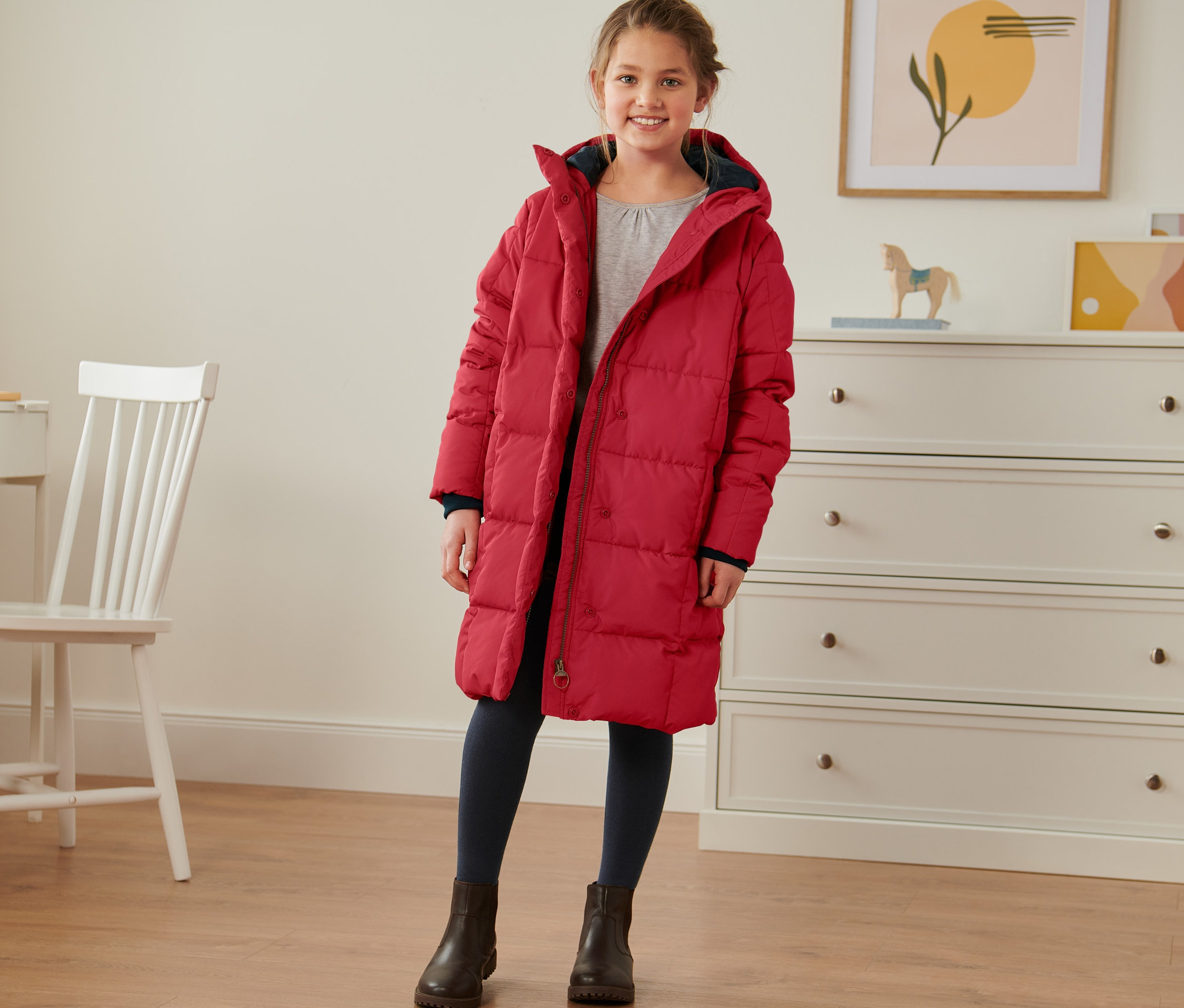 Mädchen trägt einen roten Thermomantel.