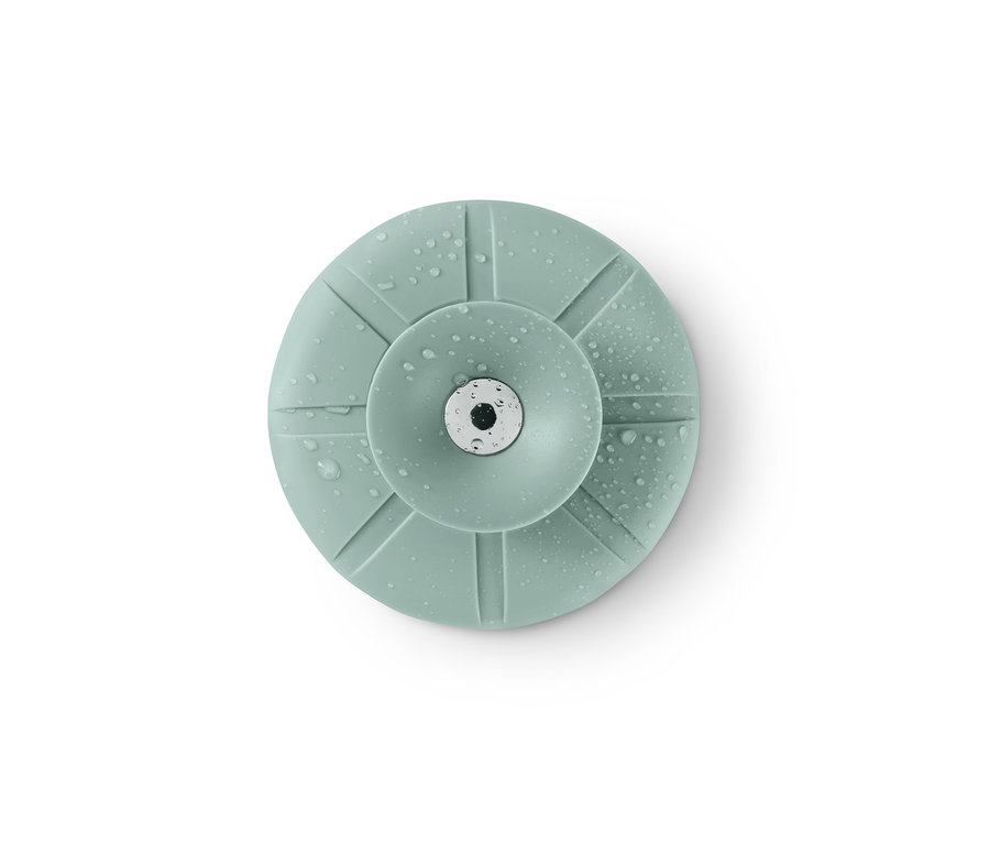 Ein grünes Abflusssieb und -verschluss mit Wassertropfen auf weißem Hintergrund.