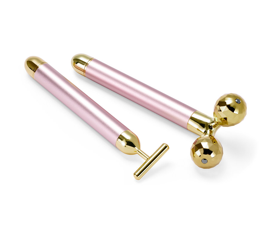 Ein 2-teiliges Gesichtsmassage-Set mit rosa Griffen und goldenen Enden.