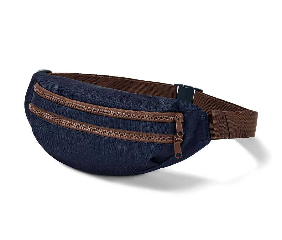 Eine marineblaue Hüfttasche mit braunen Reißverschlüssen und braunem Gurt.