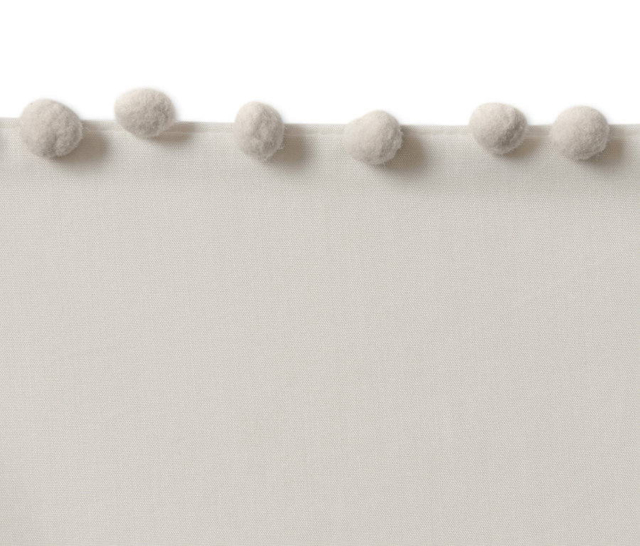 Detail einer beigen Premium-Baumwoll-Bettwäsche in Normalgröße mit Bommeln.