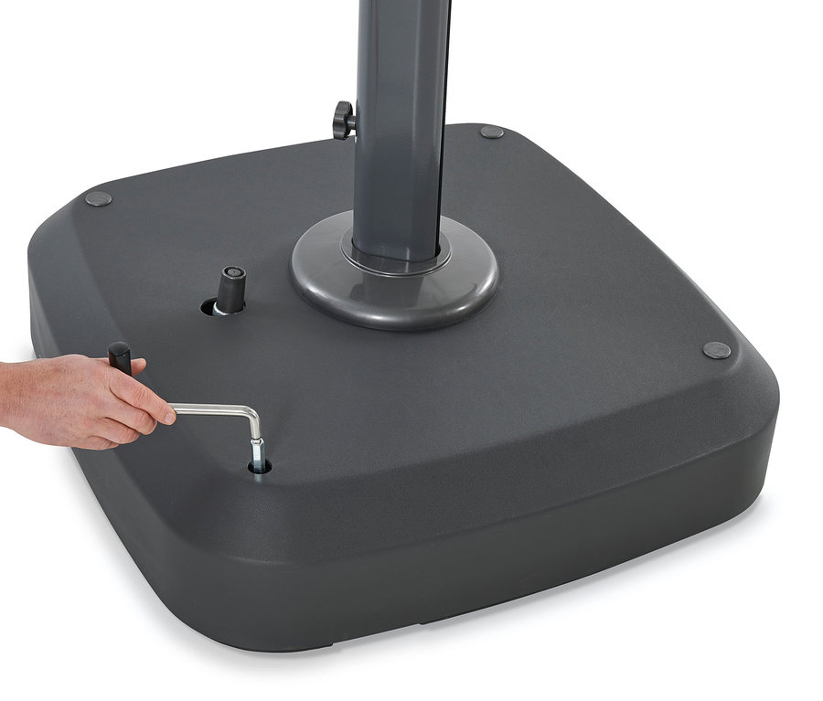 Eine Hand zieht eine Schraube an einem anthrazitfarbenen Leco Premium-Ampelschirmfuß fest.