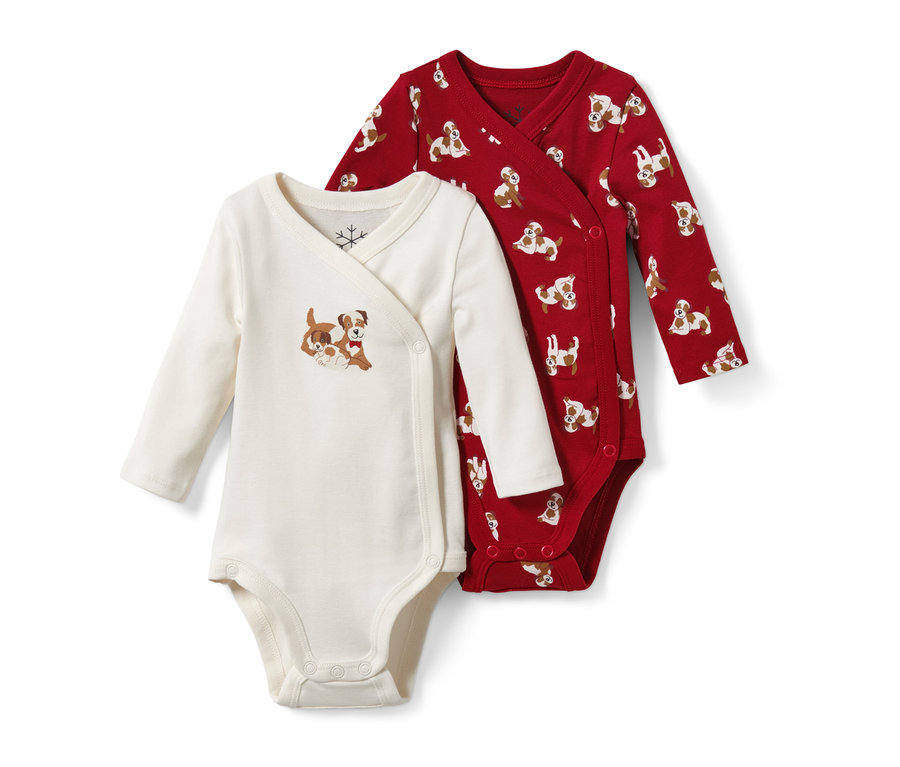 Zwei Baby-Bodys: ein cremefarbener mit Hunde-Motiv, der andere rot mit Hunde-Print.
